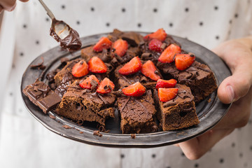 Closeup of man cook holding ready chocolate brownies