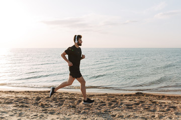 Fit young sportsman running at the beach