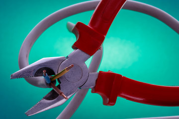 pliers and electric wire on a aquamarine background