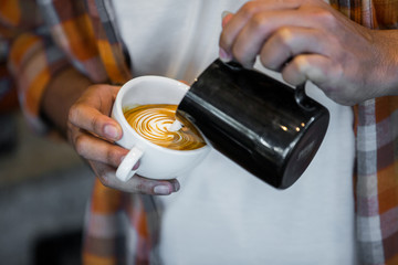 Coffee workshop barista make a Coffee latte art  Selective focus white cup.color vintage style.