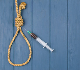 Drugs are suicide. A syringe in a loop for the gallows.