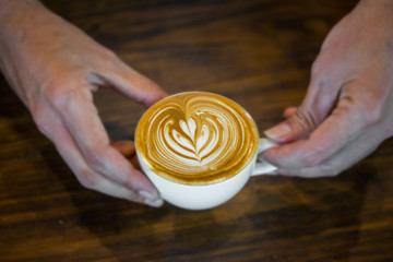 Coffee workshop barista make a Coffee latte art  Selective focus white cup.color vintage style.