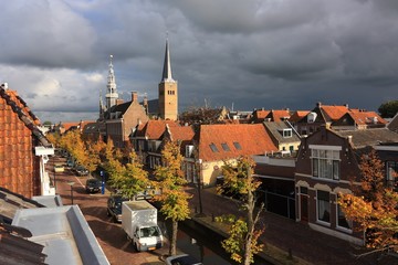 Fototapeta premium View on Franeker The Netherlands from Noord with Martinikerk and old city hall against a stormy sky in autumn