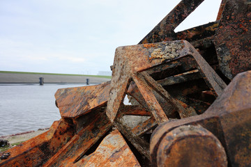 A group of pointy rusty brown red  anchors in the harbour of Harlingen, The Netherlands