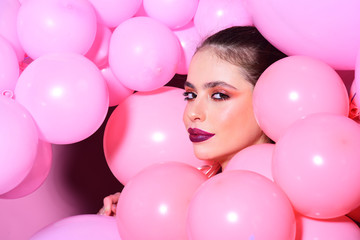 Fototapeta na wymiar Birthday decor and celebration. Retro girl with stylish makeup and hair. girl dreaming in punchy pastels trend. Fashion woman with many pink air balloons. Balloon party on pink studio background