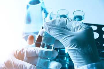 Researcher with glass laboratory chemical test tubes with liquid for analytical , medical,...