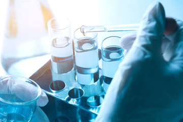 Researcher with glass laboratory chemical test tubes with liquid for analytical , medical,...
