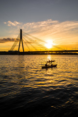 fantastic sunset with a bridge and canoes | Riga, Latvia