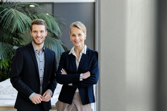 Businesswoman And Man In Office Corridor, Portrait