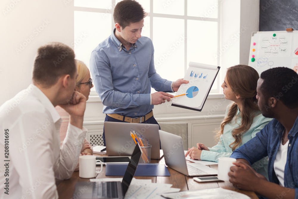 Poster man giving presentation to colleagues in office