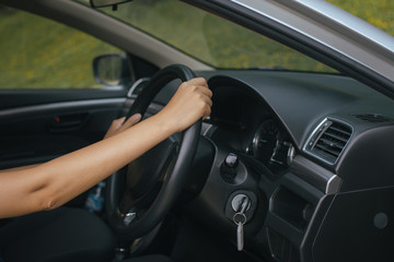 Fototapeta na wymiar Hands of female driver on steering wheel,Woman driving a car