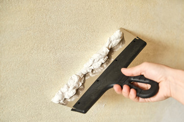 Spatula with putty in hand. Close-up.