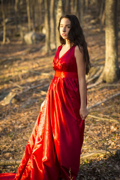 Girl in red dress waiting in woods