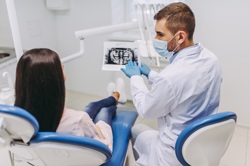 patient consulting with dentist looking at x-ray