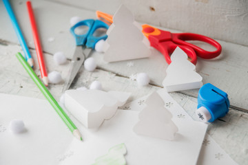 Creative paper Christmas tree on white paper sheet, scissors and colorful crayons on color table...