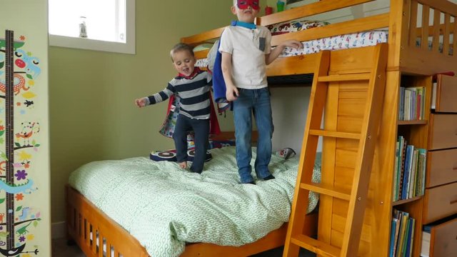 Slow motion of two little brothers in capes playing super heros
