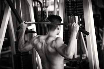 Fototapeta na wymiar Portrait of young man using weight lifting equipment , bodybuilder concept.