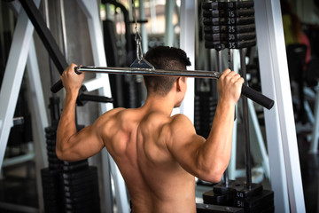 Fototapeta na wymiar Portrait of young man using weight lifting equipment , bodybuilder concept.