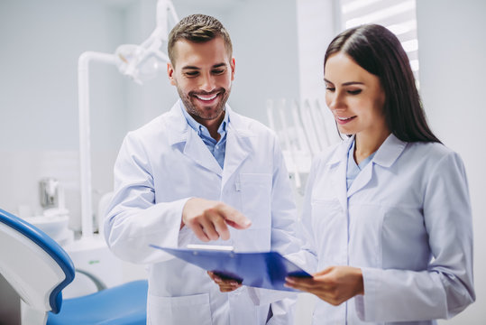 dentist and assistant looking at clipboard