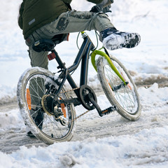 Closeup photo of guy riding bicycle on snowy background