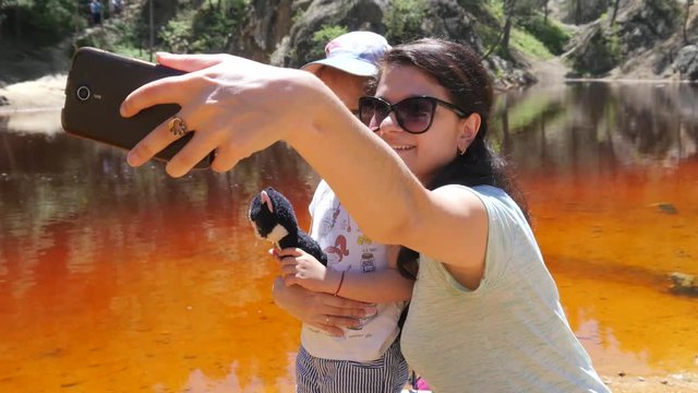 Nature park Colored lakes in Poland, mother take phone selfie with little child daughter