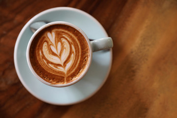 cappuccino or Latte art coffee made from milk on the wood table in coffee shop