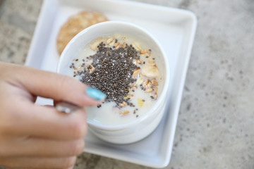 Cereal on milk in cup with woman hand breakfast
