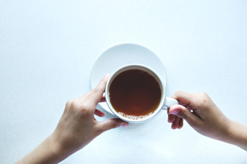 Cup of black tea with hands. Isolated on white background
