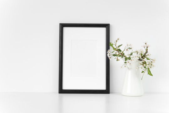 Black A4 passepartout frame mock up with spring cherry bouquet. Mock up for your photo, design or text.