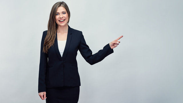 Business woman wearing black suit pointing finger to copy space.
