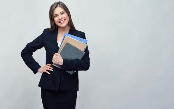 Smiling woman in black suit holding book and business paper.