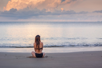 Woman in bikini sitting relax on the beach.