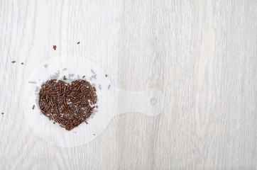chocolate chips arranged into a heart shape on wight table