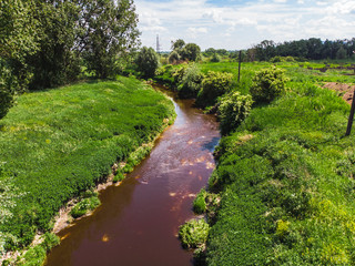 Fototapeta na wymiar dirty brown river. pollution concept. green riverside