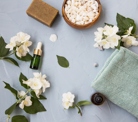 Spa and skincare flatlay setting with jasmine oil and flowers
