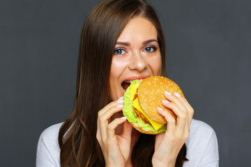 Young woman biting burger. Close up isolated portrait