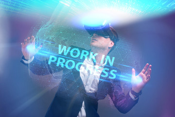 Business, Technology, Internet and network concept. Young businessman working in virtual reality glasses sees the inscription: Work in progress