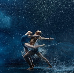 Fototapeta na wymiar Young couple of ballet dancers dancing unde rwater drops