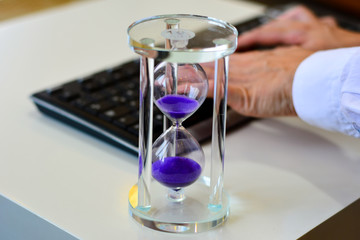 Time is money, make money and time management business and technology concept, hourglass on laptop keyboard macro view. deadline idea, symbol, concept