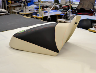Seat from the motorcycle on the table after replacing the leather plating and embroidering in the...