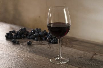 kieliszek czerwonego wina i kiść winogrona