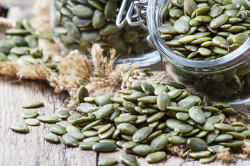 Raw pumpkin seeds, healthy snack, vintage wood background, selective focus