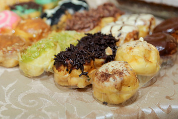 Sweet mini donuts glazed with any topping greentea, strawberry, chocolate on the table