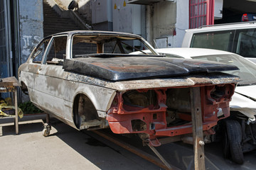 A wrecked car on lift in the street 