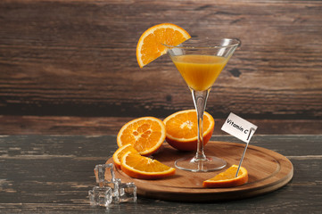 sok pomarańczowy w kieliszku i napis witamina C