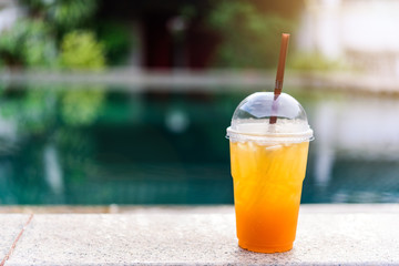 A glass of Lemon honey soda juice with background of swimming pool.