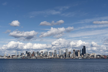 Fototapeta na wymiar Seattle skyline afternoon partly cloudy sky viewed from west Seattle across Elliott bay