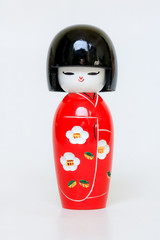 Obraz premium Japanese Wooden Doll Wearing A Red Kimono