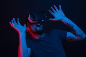 Shocked man in VR glasses on black