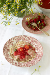 A hearty homemade breakfast or lunch - dumpling or vareniki with strawberries and strawberry sauce. Rustic style.